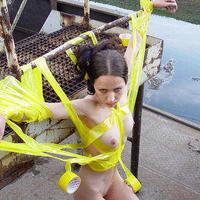 A girl is tied by yellow tape on a construction pitch