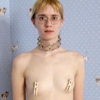 Slim young blonde enjoys pegs and chains all over her body