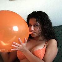 Cute latina blowing up a huge balloon