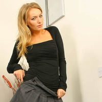 Saucy secretary Hayley-Marie in a revealing outfit with patterned grey pantyhose and kinky black boots.
