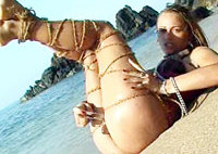 Beach babe in collar and bondage breaking free from a short lead and dildoing on the surf line