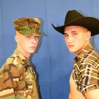 A cowboy and a soldier posing naked in front of mirrors