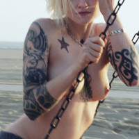 tattooed blonde gets naked at the beach