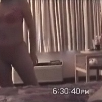 Girl standing naked in her bedroom