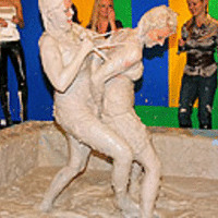 Two hot cuties wrestling together in the dirty mud