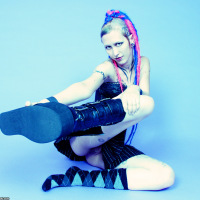 Tattooed Goth-punk girl in schoolgirl skirt